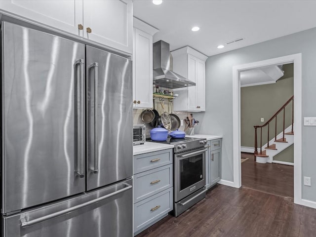 9 Cresthill Pl, Smithtown, NY 11787 - kitchen featuring stainless steel appliances, wall chimney range hood, dark wood finished floors, light countertops, and baseboards