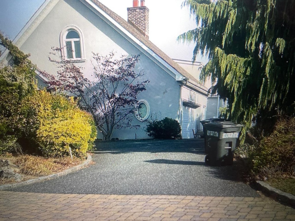 view of side of property with a chimney and stucco siding