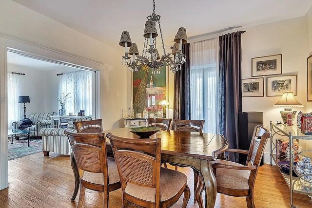 dining space with light wood-style flooring and a chandelier