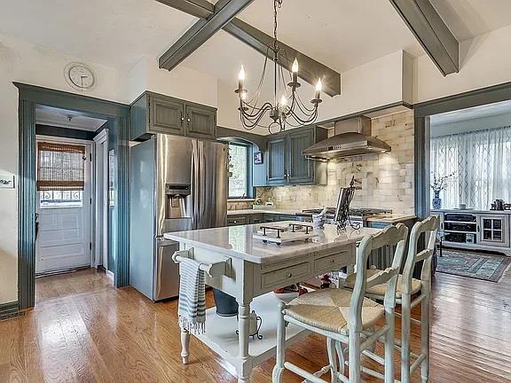 kitchen featuring light countertops, backsplash, stainless steel refrigerator with ice dispenser, and a wealth of natural light
