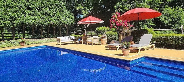 pool featuring fence and a patio area