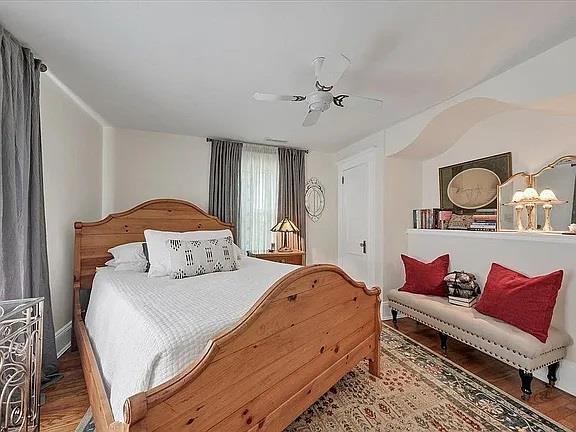 bedroom with baseboards, ceiling fan, and wood finished floors