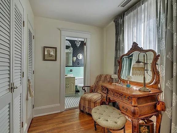 sitting room with baseboards, wood finished floors, and visible vents