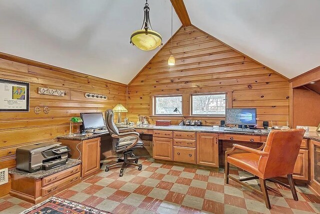 office area with lofted ceiling with beams, wood walls, and built in desk