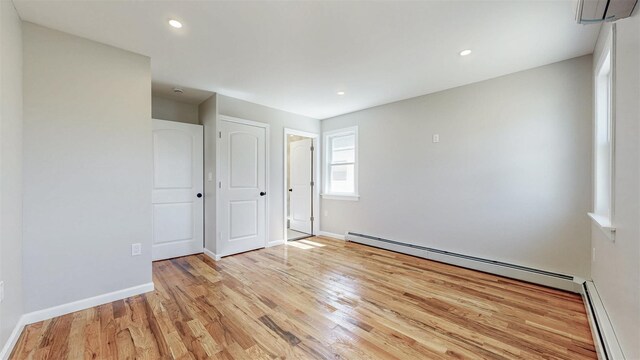 13108 160th St, Jamaica, NY 11434 - empty room featuring light wood-style floors, a baseboard heating unit, baseboards, recessed lighting, and a wall mounted air conditioner