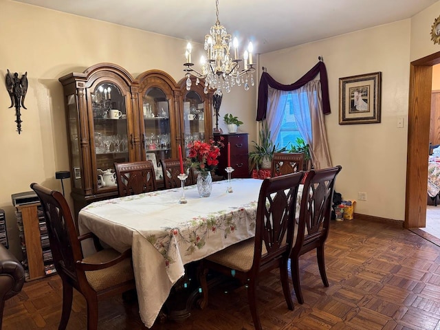 dining space with baseboards and a chandelier