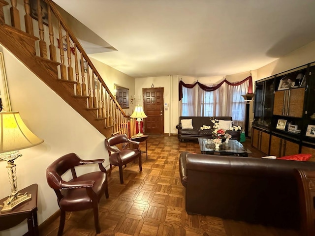 living area featuring stairs and baseboards