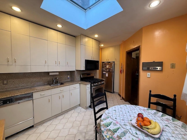 kitchen with a sink, stainless steel appliances, recessed lighting, backsplash, and a skylight