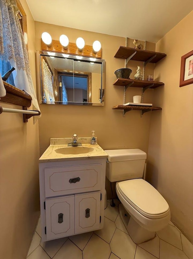 half bathroom with vanity, tile patterned floors, and toilet