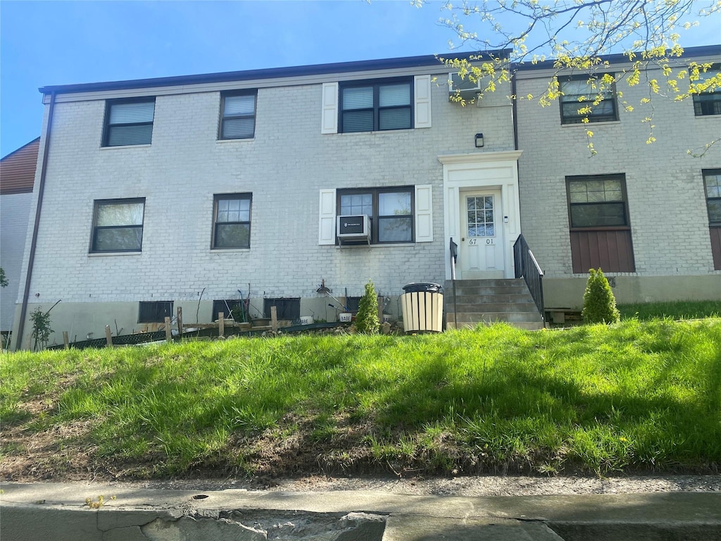 view of property featuring cooling unit and brick siding