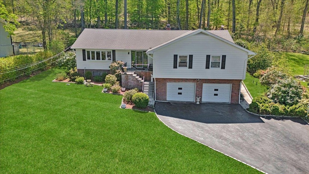 25 Gabriel Dr, Cortlandt Manor, NY 10567 - view of front of property with a garage, a front lawn, aphalt driveway, stairs, and brick siding