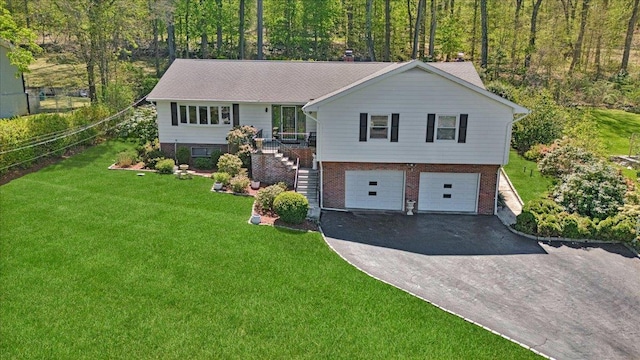 view of front of property with a garage, a front lawn, aphalt driveway, stairs, and brick siding