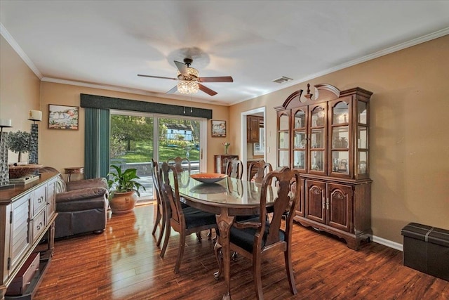 dining space with crown molding, a ceiling fan, and dark wood-style floors