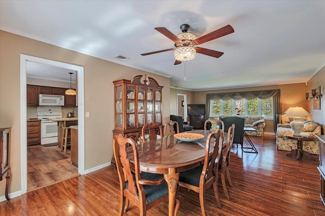 dining room featuring ceiling fan, visible vents, ornamental molding, and wood finished floors