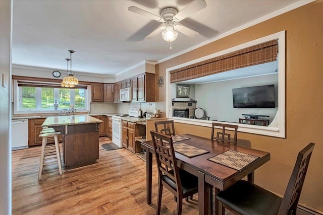 dining room with a ceiling fan, ornamental molding, light wood-style flooring, and a baseboard radiator