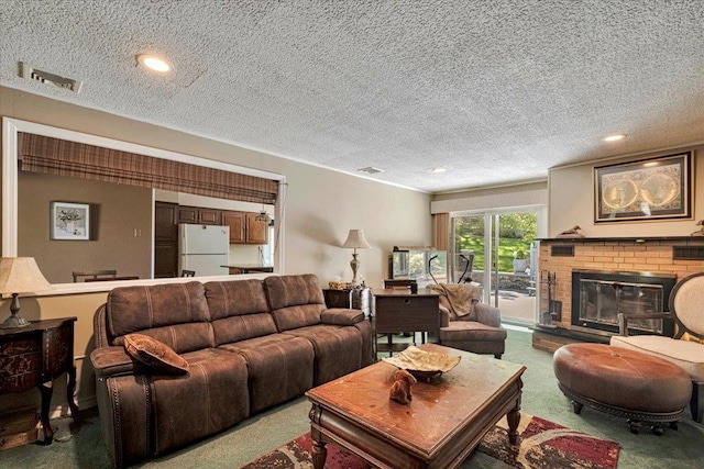 living room with carpet, a brick fireplace, a textured ceiling, and visible vents