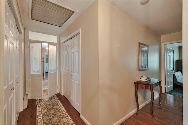 hallway with dark wood-type flooring and baseboards
