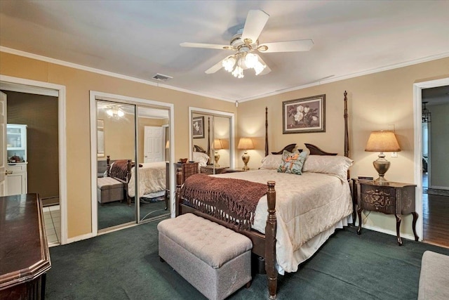 carpeted bedroom with a ceiling fan, visible vents, crown molding, baseboards, and two closets