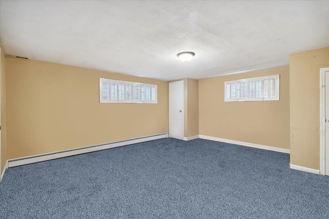 basement with baseboards, a textured ceiling, carpet, and baseboard heating