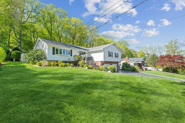 view of front of house featuring an attached garage, driveway, and a front yard