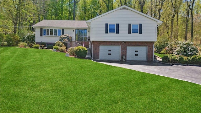 view of front of home with brick siding, an attached garage, a front yard, and aphalt driveway