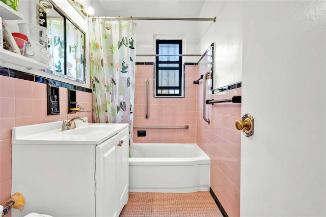bathroom with shower / bath combo with shower curtain, vanity, tile patterned floors, and tile walls