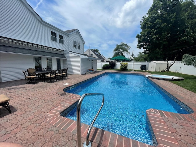79 Constellation Rd, Levittown, NY 11756 - view of pool with a fenced backyard, a storage unit, a patio, outdoor dining area, and a pool with connected hot tub