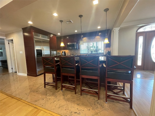 79 Constellation Rd, Levittown, NY 11756 - kitchen featuring appliances with stainless steel finishes, ornamental molding, decorative backsplash, dark countertops, and decorative columns