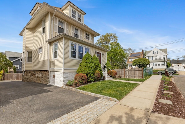 view of front of property with fence and a front lawn