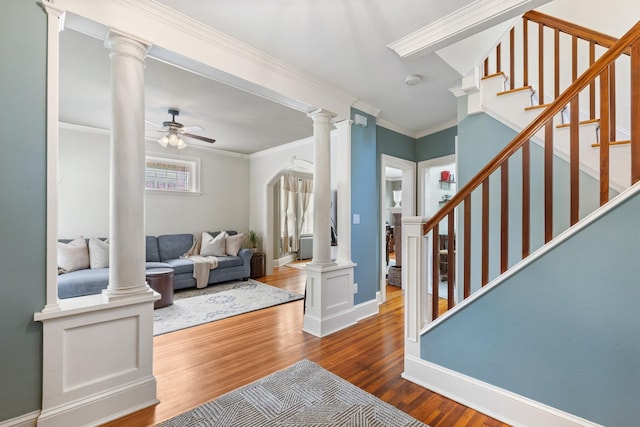 living area with baseboards, ceiling fan, wood finished floors, and stairway
