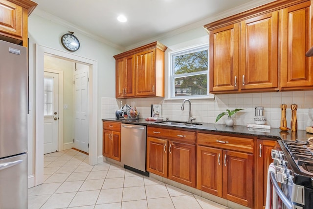 kitchen with brown cabinetry, decorative backsplash, light tile patterned flooring, a sink, and appliances with stainless steel finishes