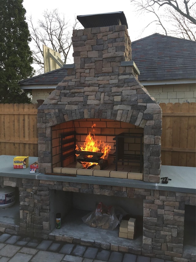 details with an outdoor stone fireplace and fence