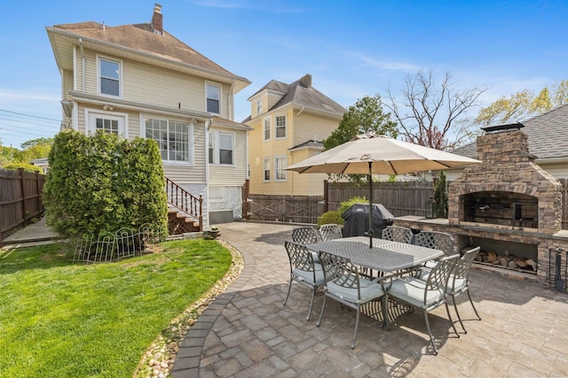 view of patio featuring area for grilling, an outdoor stone fireplace, and fence