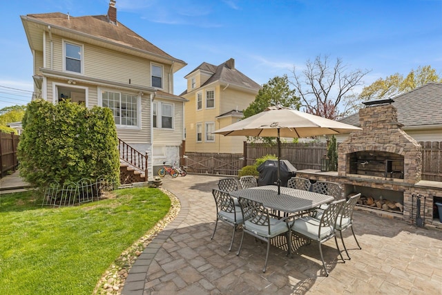 view of patio with a fenced backyard, outdoor dining area, area for grilling, and an outdoor stone fireplace