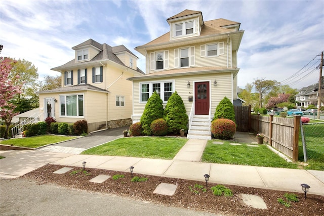 traditional style home featuring fence and a front yard