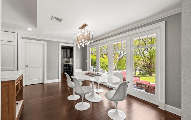 dining room with visible vents, dark wood finished floors, baseboards, an inviting chandelier, and ornamental molding
