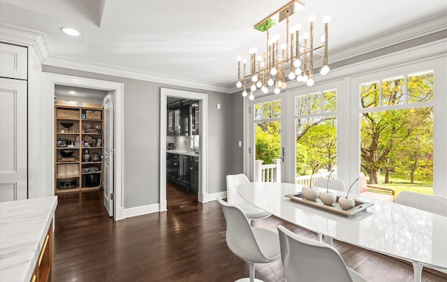 dining space featuring baseboards, a notable chandelier, ornamental molding, and dark wood finished floors