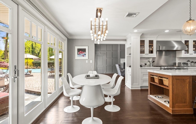 dining space with an inviting chandelier, ornamental molding, dark wood-type flooring, and visible vents