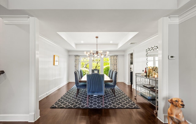 dining space featuring an inviting chandelier, a raised ceiling, recessed lighting, baseboards, and dark wood-type flooring