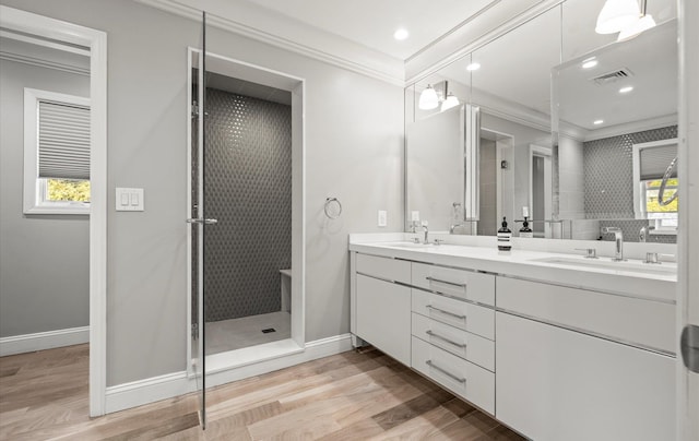 bathroom featuring crown molding, visible vents, a sink, and wood finished floors