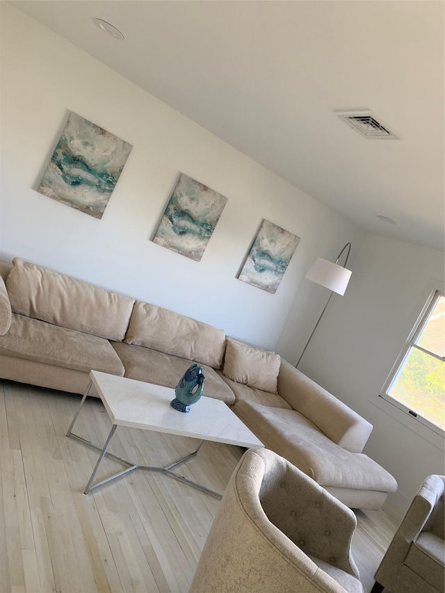 living area with wood finished floors and visible vents