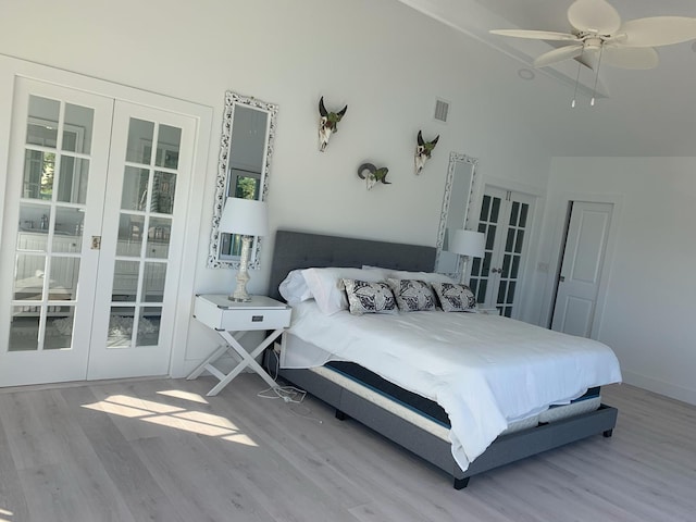 bedroom featuring french doors, wood finished floors, visible vents, and high vaulted ceiling