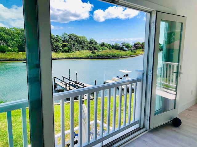 balcony with a boat dock, a water view, and boat lift