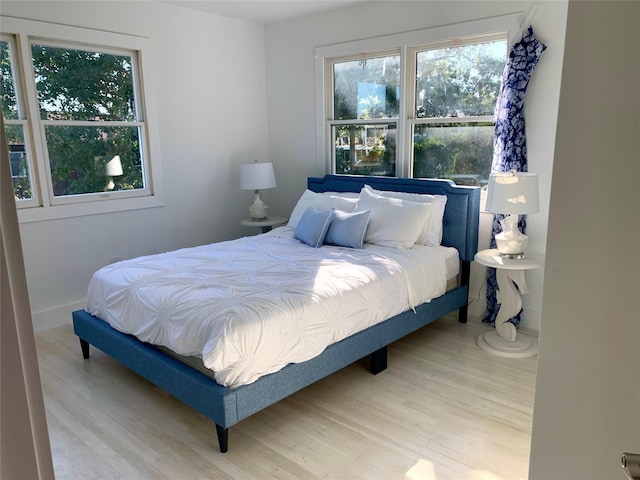 bedroom featuring multiple windows and wood finished floors