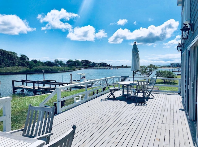 dock area featuring outdoor dining area and a water view