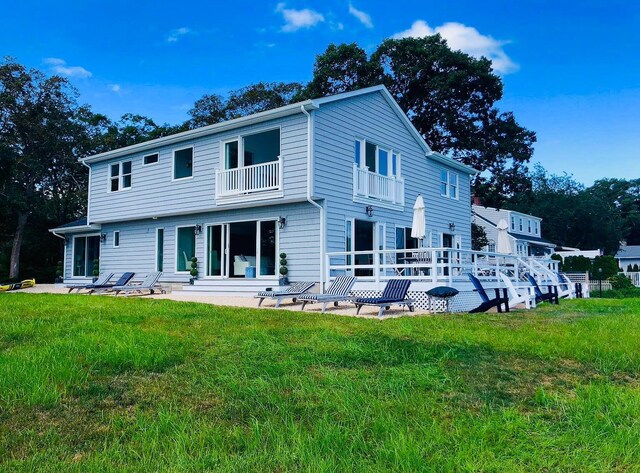 23 Nautilus Dr, Hampton Bays, NY 11946 - back of house featuring a balcony, a lawn, and a patio area