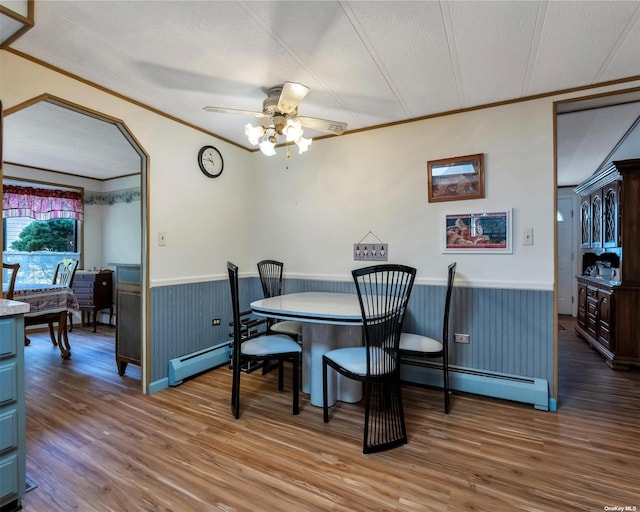 1407-54 Middle Rd Unit 54, Calverton, NY 11933 - dining space featuring a baseboard radiator, ornamental molding, wainscoting, and wood finished floors