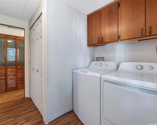 1407-54 Middle Rd Unit 54, Calverton, NY 11933 - laundry room featuring baseboards, light wood-type flooring, cabinet space, and washing machine and clothes dryer