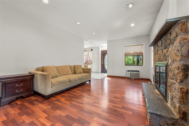living area featuring recessed lighting, heating unit, a stone fireplace, and dark wood-type flooring