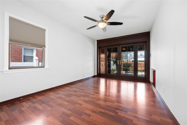 unfurnished room with a ceiling fan, wood finished floors, and a wealth of natural light